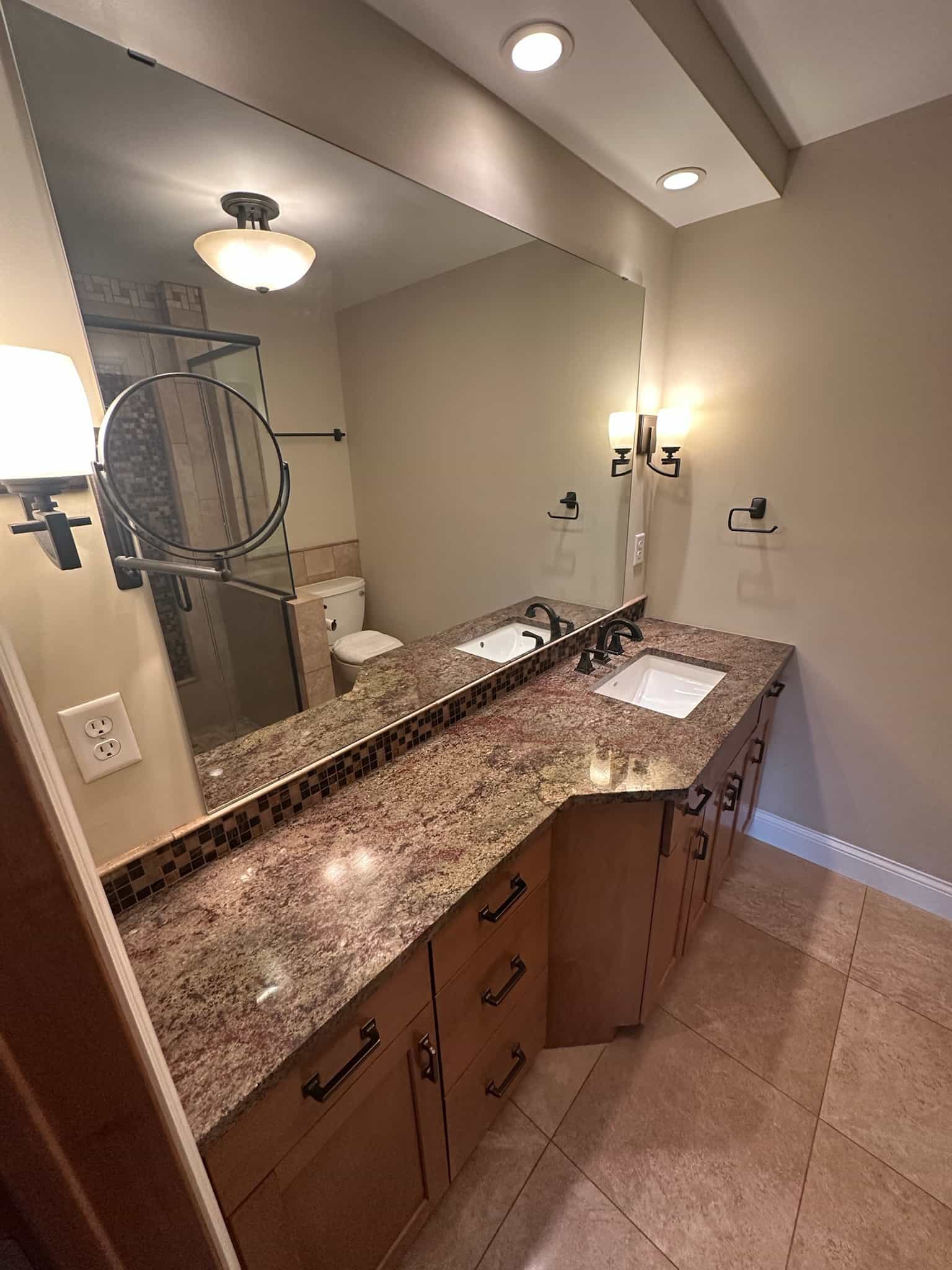 Granite vanity with a mosaic tile backsplash