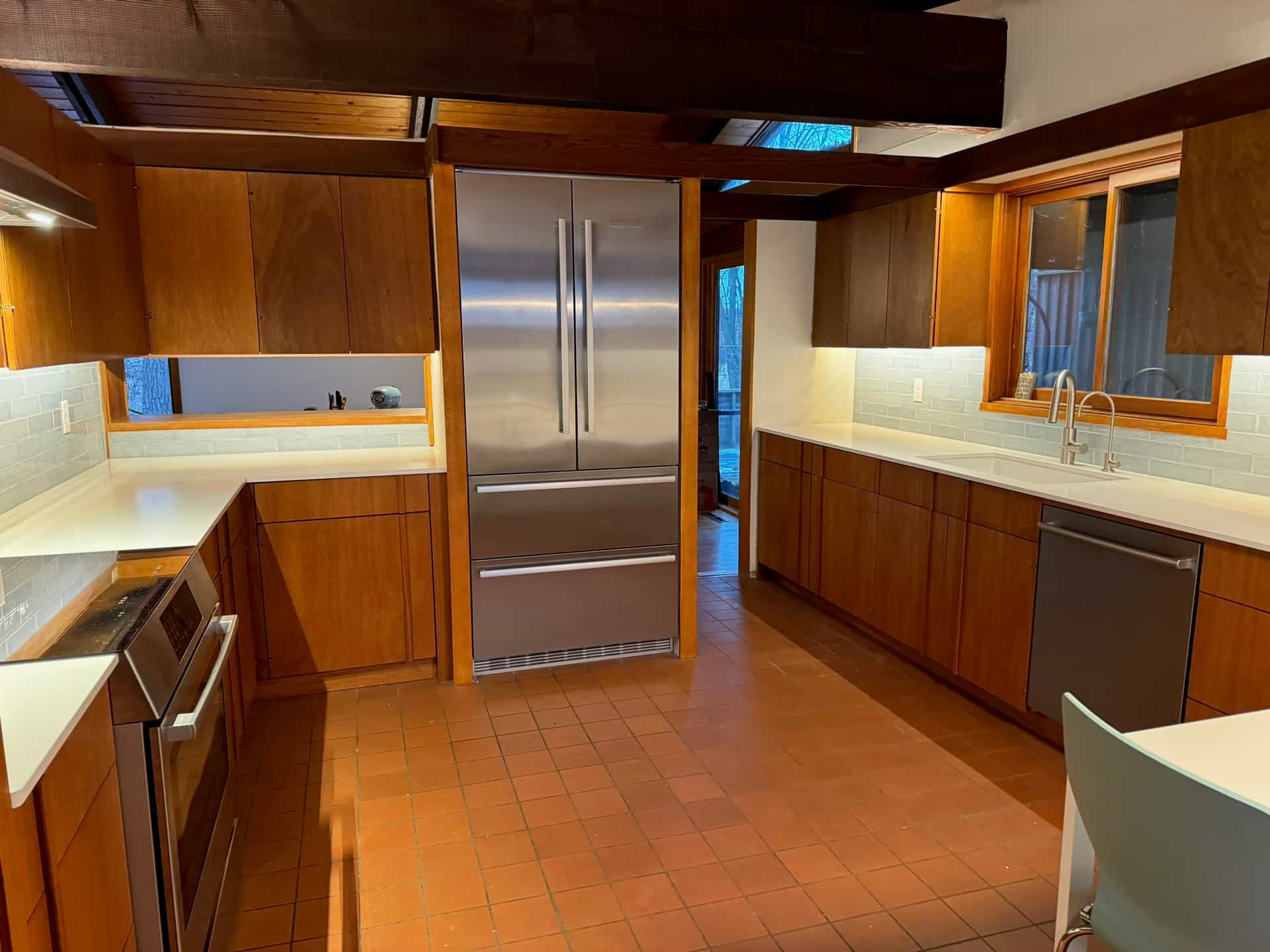 Warm wood cabinetry with quartz counters and a subway tile backsplash