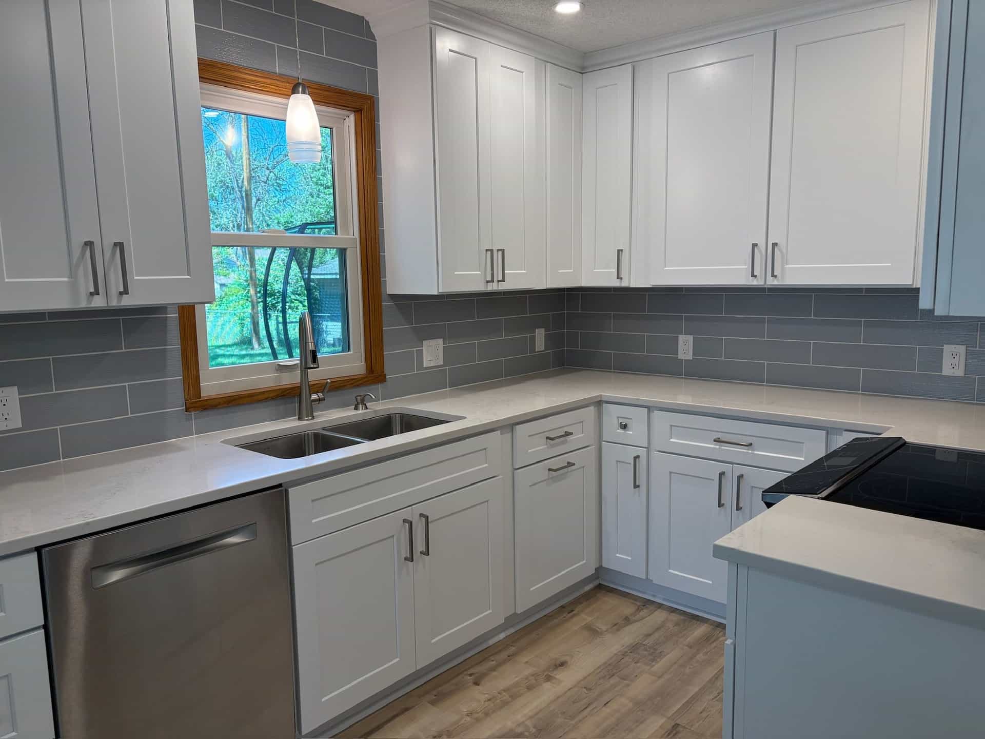 White cabinets and gray subway tile around the window