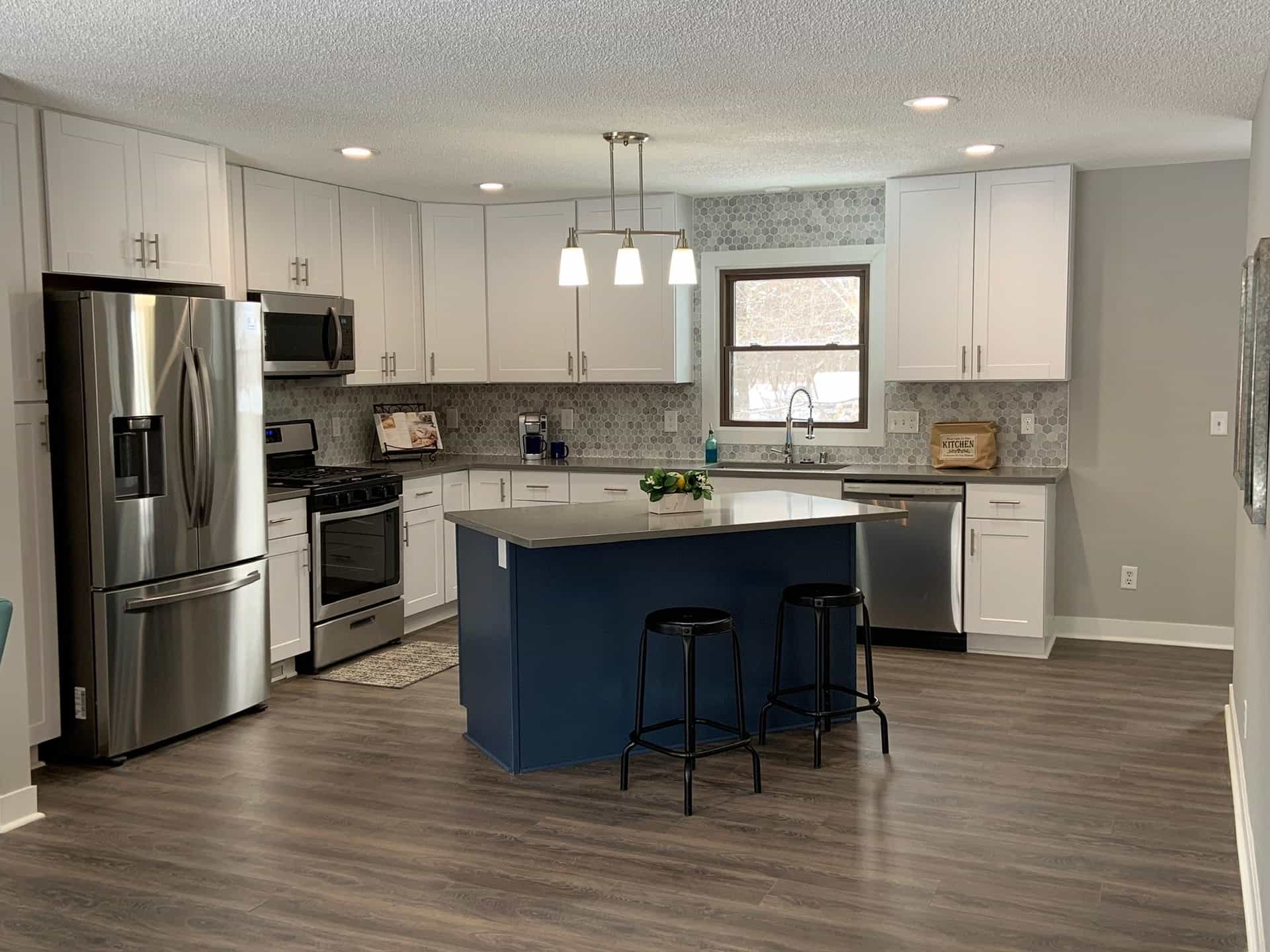 White shaker cabinets with a navy island and pendant lighting